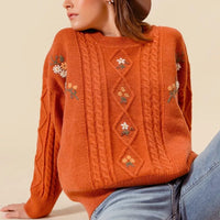 Brick cable-knit sweater with embroidered flower accents and diamond pattern panels