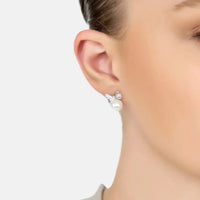 Silver stud earrings with bow ribbon and round white pearl worn on ear
