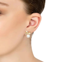 Gold ribbon bow pearl stud earrings on model ear with small crystal bow and pearl