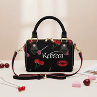 Black handbag with cherry and lip design, featuring the name 'Rebecca', on a light background.