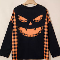 Black long-sleeve top with orange plaid pumpkin face graphic on front