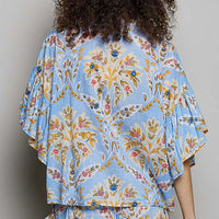 Blue floral printed woven shirt with ruffle sleeves and elastic waist, back view