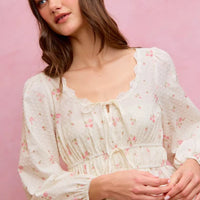White floral clip-dot blouse featuring scalloped lace trim along the neckline and cuffs