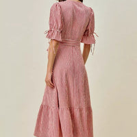 Back view of red and white striped wrap midi dress with puff sleeves and tie belt
