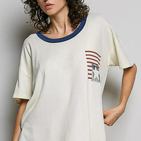 Cream cotton top with blue neckline trim and chest American flag graphic