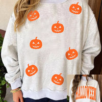 Light gray sweatshirt with orange pumpkin face print, mock neck