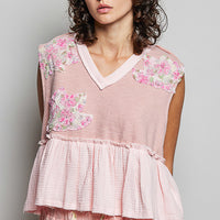 Powder pink sleeveless top with V-neck and tiered ruffle hem with floral patches