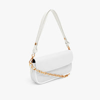 White mini shoulder bag side view with gold chain strap and curved flap.