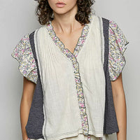 Cream V-neck blouse with floral ruffle sleeves, vertical trim, and button front