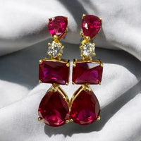 Gold drop earrings with ruby-red stones and small clear accent stones