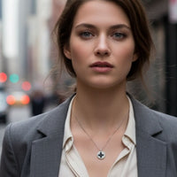 Silver necklace with circular four-leaf clover pendant worn at the collarbone