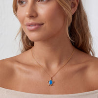 Gold pendant necklace with blue oval opal charm on a fine chain.