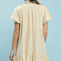 Cream mini shift dress, back view with gathered tiers and short sleeves.