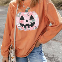 Orange sherbet tunic sweatshirt with long sleeves and patchwork pumpkin face graphic