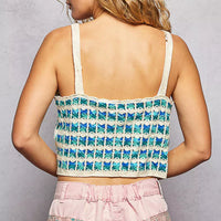 Back view of blue-and-white crocheted cropped cami with scalloped edge and thin straps