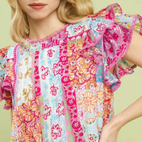 Close-up of pink patchwork mini dress with flutter sleeves and floral print