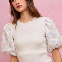 White knit crewneck sweater top with floral puff sleeves and scalloped hem