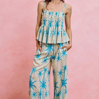 Blue palm-print smocked cami top with straight neckline, adjustable straps, peplum hem