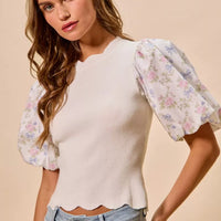 White ribbed sweater top with pastel floral contrast sleeves and scalloped hem