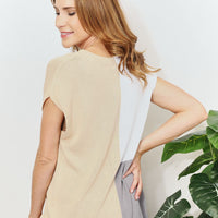 Back view of color-block knit top; beige and gray panels with short sleeves