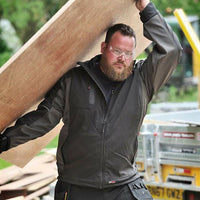 Men's Tuffstuff Stanton softshell jacket worn with full zip, stand collar and chest pocket.