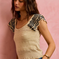 Oatmeal wavy knit top with black zigzag flutter sleeves and fitted waist