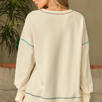 Ivory long-sleeve sweatshirt with contrast stitching, crew neck, and banded back