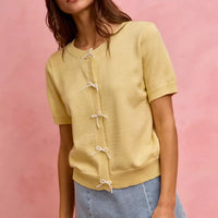 Light blue denim mini skirt with lace ribbon bows and a frayed hem.