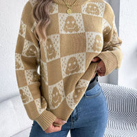Ghost-pattern checkered round-neck sweater in tan and cream with ribbed hem.