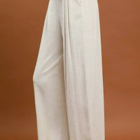 Cream high-waist wide-leg trousers with front pleats and relaxed straight legs