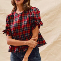 Red plaid peplum top with ribbon-tied short puff sleeves and peplum hem