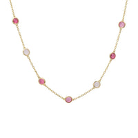 Gold necklace with pink and light blue bead charms on a fine chain