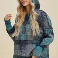 Plaid fleece hoodie with hood, half-zip, dropped shoulders, side view with hand pocket.