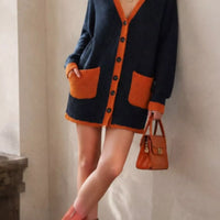 Dark navy knit V-neck cardigan with orange trim, button front, and patch pockets