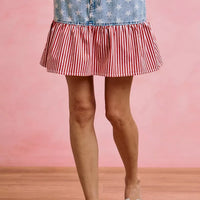 Blue denim mini skirt with star print top panel and red-and-white striped ruffle hem.