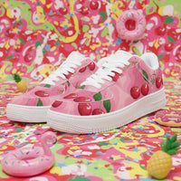 Pink sneakers with cherry design on a colorful background