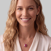 Gold chain ruby pendant necklace with red square pendant shown on a model