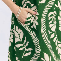 Close-up of green mini dress fabric with cream leafy and stripe pattern