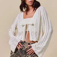 Off-white textured open-front cardigan with ribbon tie and draped long sleeves