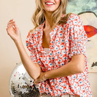 Orange floral V-neck puff sleeve top with smocked bodice and ruffled short hem
