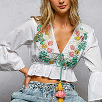 Ivory cropped blouse with floral embroidery V-neck, ruffled hem and tassel tie