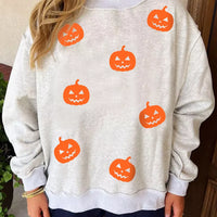 Light gray sweatshirt with scattered orange jack-o’-lantern face prints