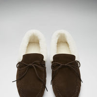 Pair of brown suede slippers shown from above, with cream lining and lace-up fronts