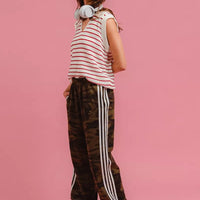 Camouflage track pants with white side stripes and cuffed ankle openings.