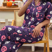 Halloween pajama set: purple button-up top and pants with bats, ghosts, and jack-o'-lantern prints