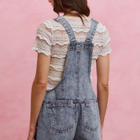 Light wash denim overall romper with adjustable straps and back yoke, two back pockets