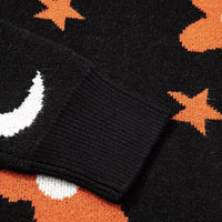 Black sweater cuff and hem with ribbed knit and orange star and flower pattern