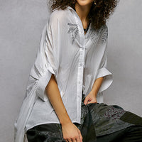 Ivory embroidered floral button-front shirt with draped sleeves and high-low hem