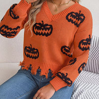 Orange V-neck sweater with black pumpkin motifs, frayed distressed hem and ribbed cuffs