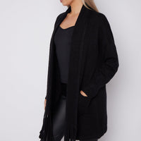 Black fringed shawl-collar cardigan with open front and tassel-trimmed hem